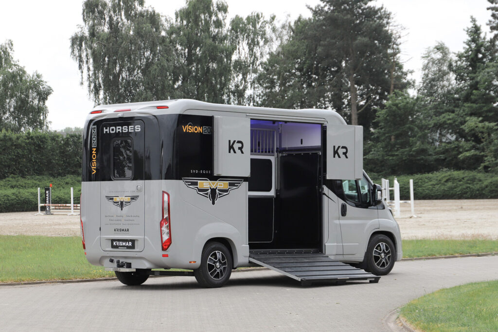 Achterkant van een Krismar paardenwagen in een grijze kleur met de laadklep open.