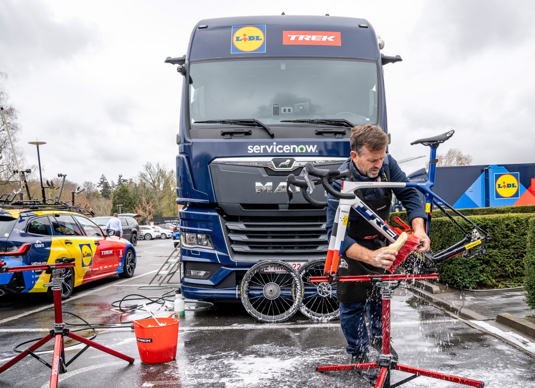 Lidl-Trek mechanic cleaning a team bicycle in front of the custom mobile workshop built by Krismar Motorhomes.